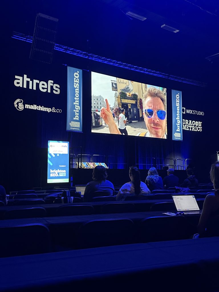 a large stage with a large television screen for the brighton seo conference